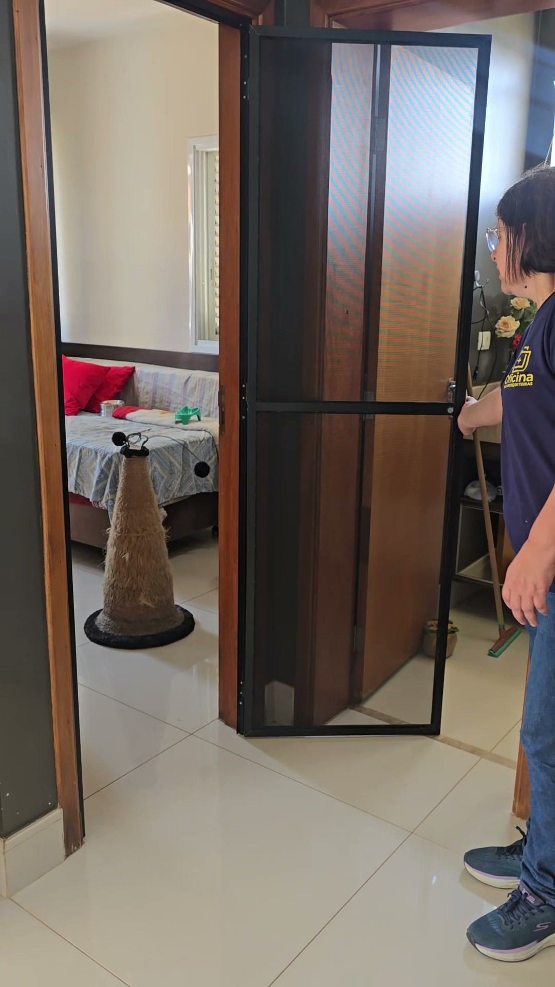 Porta de tela aberta, mostrando que a porta de madeira original continua instalada no mesmo vão