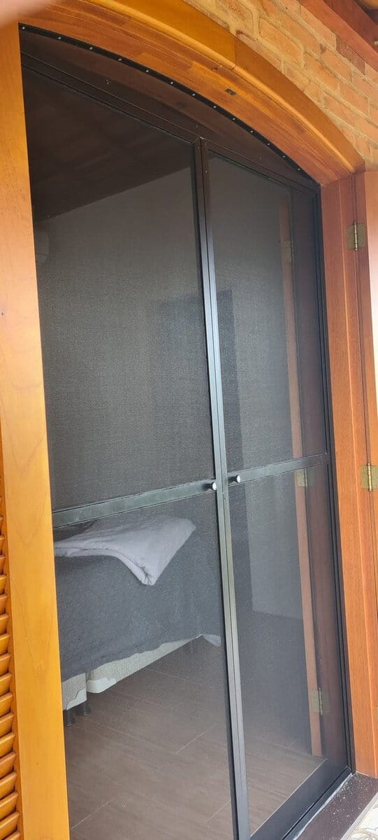 Porta de madeira em arco em Rio das Pedras com porta de tela mosquiteira feita sob medida, com o topo cortado no mesmo arco da madeira