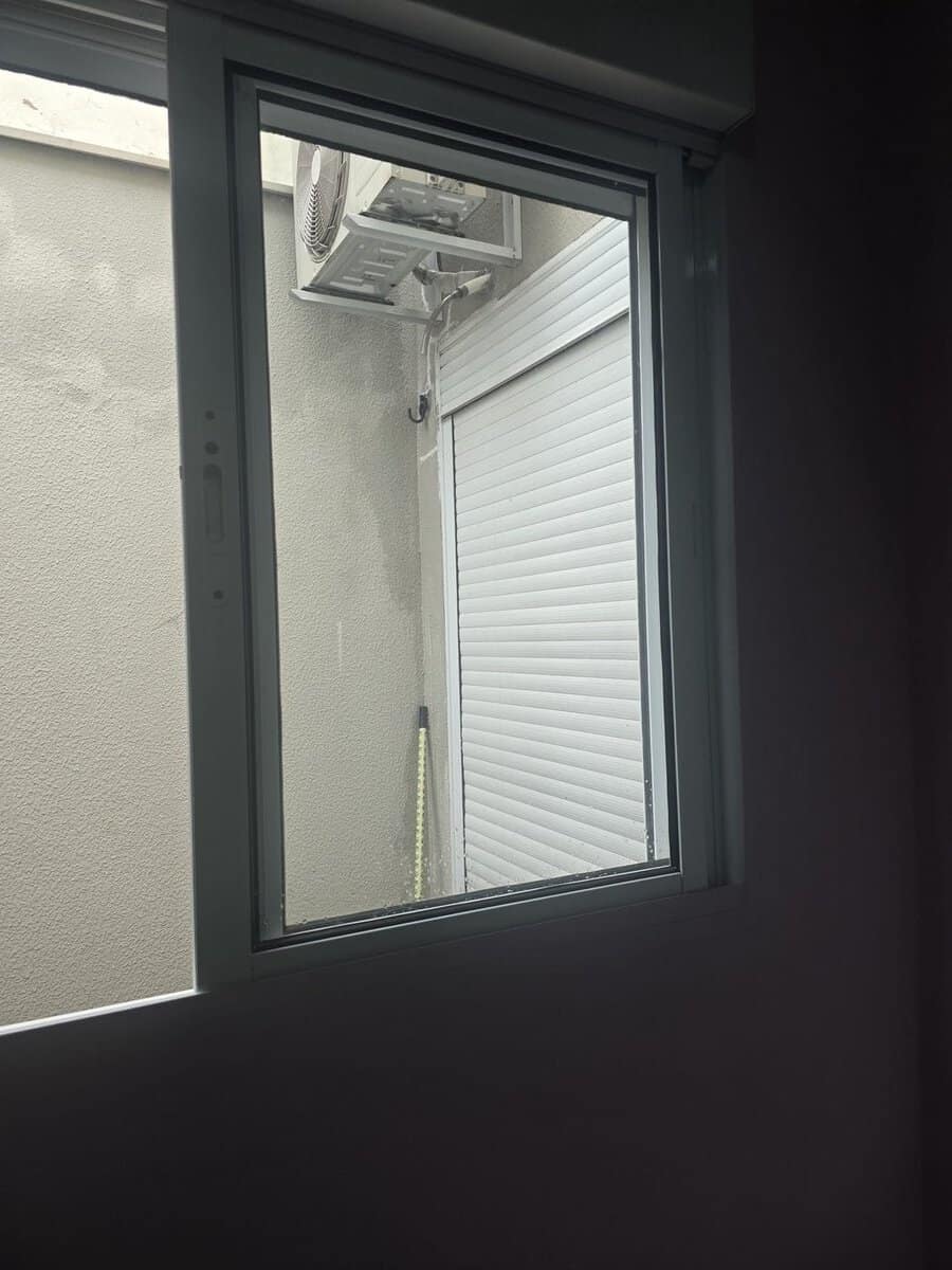 Vista de dentro de casa através de uma tela mosquiteira em Piracicaba, mostrando a área externa nítida através da malha