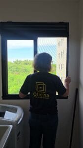 Janela de cozinha com tela mosquiteira de quadro preto instalada pela Oficina Telas Mosquiteiras em Piracicaba, com um quadro de tela separado na ventilação do gás, acima da janela