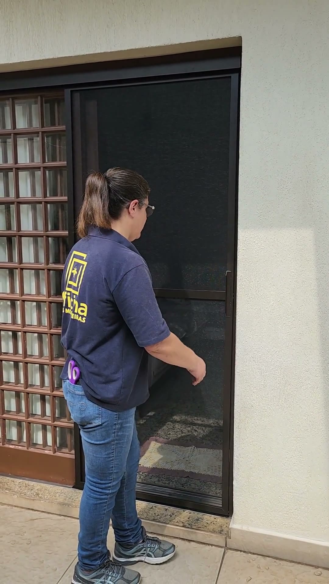 Tela mosquiteira de correr fechada ao lado de uma porta-balcão de correr de madeira, feita pela Oficina Telas Mosquiteiras