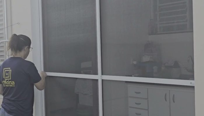 Porta de correr de tela mosquiteira com duas folhas brancas fechando o vão inteiro da porta da cozinha, em Piracicaba