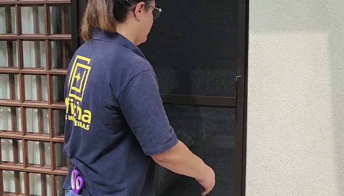 Tela mosquiteira de correr fechada ao lado de uma porta-balcão de correr de madeira, feita pela Oficina Telas Mosquiteiras